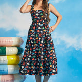 Woman wearing sleeveless square neck midi dress with underwater novelty print and pockets