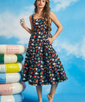 Woman wearing navy tiered fit-and-flare midi dress with colorful ocean print and square neckline