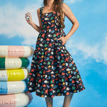 Woman wearing navy tiered fit-and-flare midi dress with colorful ocean print and square neckline