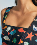 Close-up of square neckline on navy novelty print dress with fish and starfish pattern