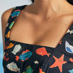 Close-up of square neckline on navy novelty print dress with fish and starfish pattern