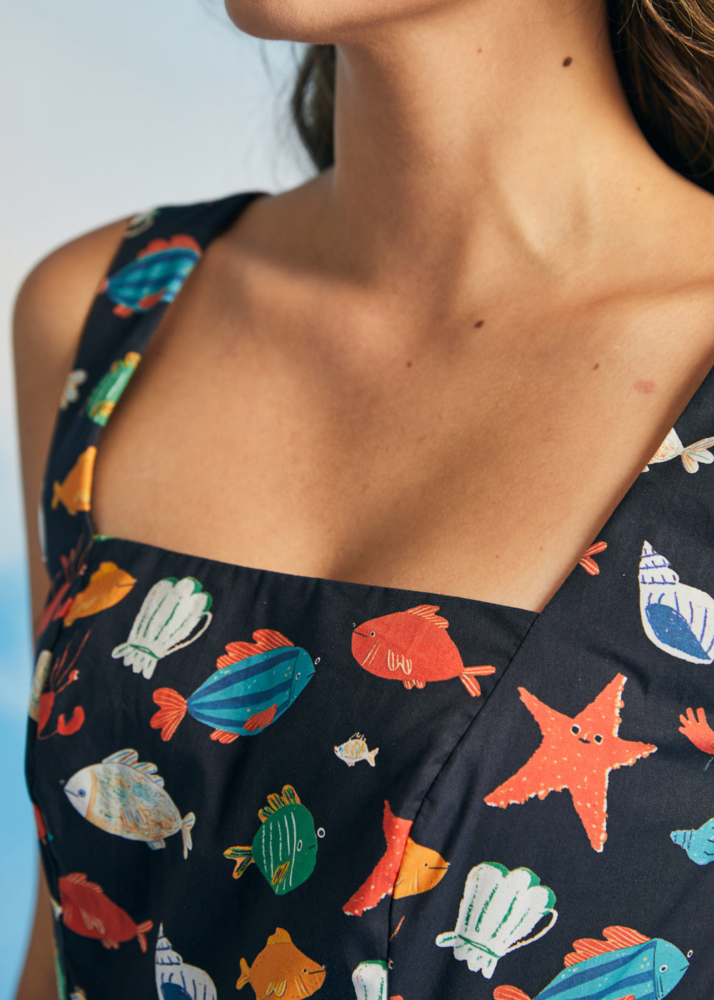 Close-up of square neckline on navy novelty print dress with fish and starfish pattern