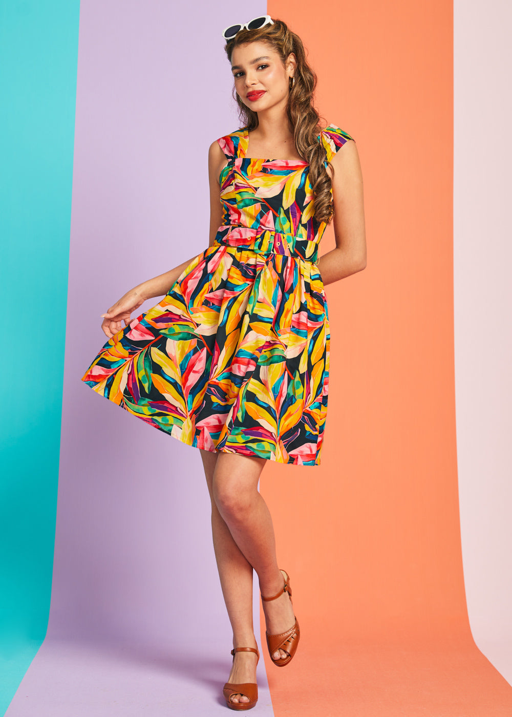 Woman wearing colorful tropical print fit-and-flare mini dress with square neckline and belt