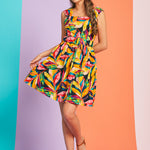 Woman wearing colorful tropical print fit-and-flare mini dress with square neckline and belt