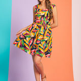 Woman wearing colorful tropical print fit-and-flare mini dress with square neckline and belt