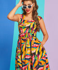 Woman wearing retro-inspired tropical print mini dress with matching belt and pockets