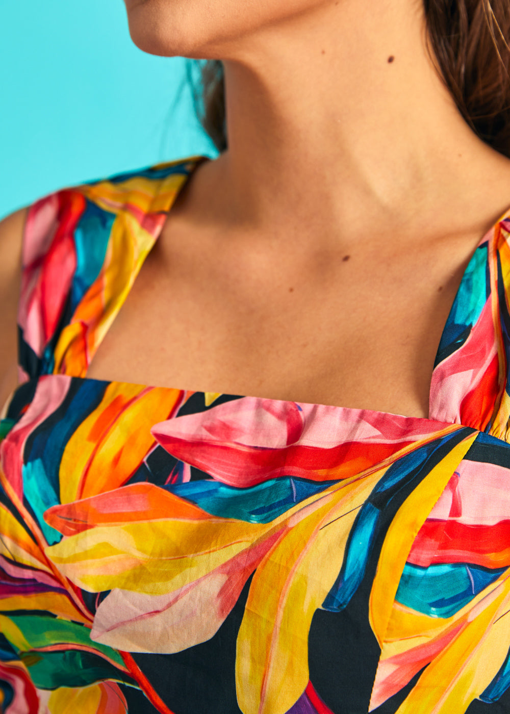 Close-up of square neckline on colorful tropical print sleeveless dress