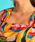 Close-up of square neckline on colorful tropical print sleeveless dress