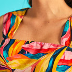 Close-up of square neckline on colorful tropical print sleeveless dress