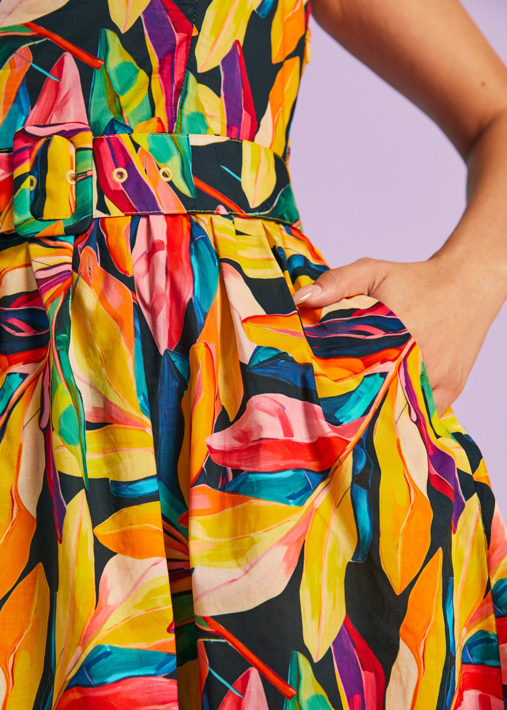 Close-up of matching belt and pocket detail on tropical print dress