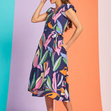 Side view of tropical print wrap-style midi dress with flutter sleeves and pockets
