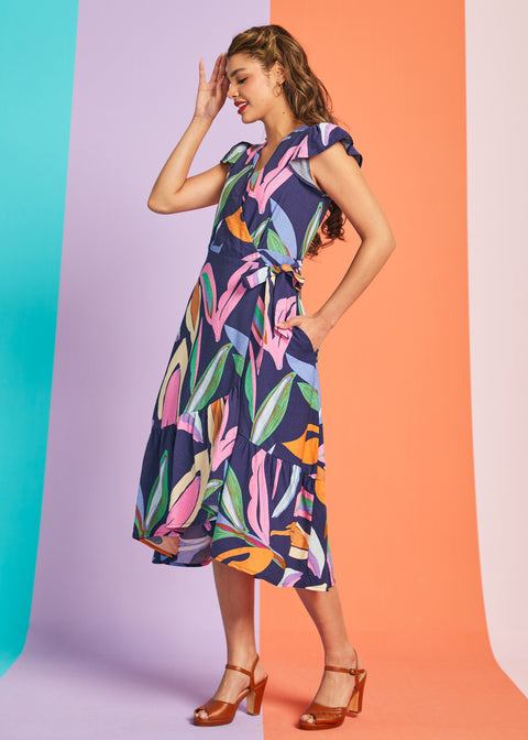 Side view of tropical print wrap-style midi dress with flutter sleeves and pockets