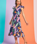 Woman wearing colorful tropical wrap dress with side tie waist and pockets