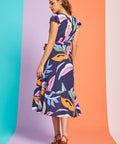 Back view of abstract botanical midi dress with flutter sleeves and asymmetrical hem