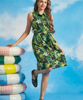 Woman posing in tropical palm print sleeveless dress with button-front closure