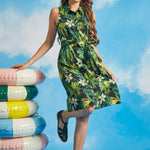 Woman posing in tropical palm print sleeveless dress with button-front closure
