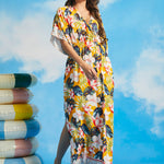 Woman wearing tropical floral maxi dress with kimono sleeves and faux-wrap neckline