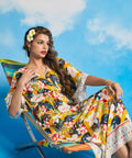 Woman lounging in tropical floral maxi dress with side slit hem