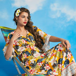 Woman lounging in tropical floral maxi dress with side slit hem