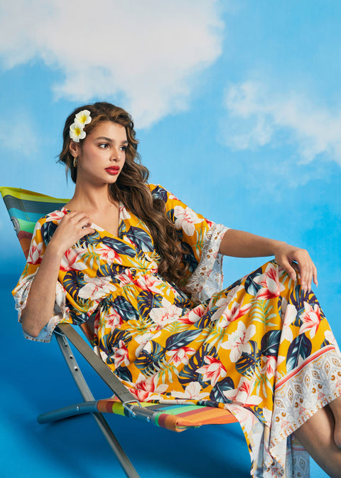 Woman lounging in tropical floral maxi dress with side slit hem