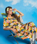 Woman reclining in tropical floral faux-wrap maxi dress with relaxed silhouette