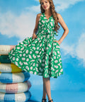 Model wearing green seashell print faux-wrap vacation dress with waist tie and flowy skirt