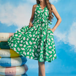 Model wearing green seashell print faux-wrap vacation dress with waist tie and flowy skirt