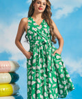Green sleeveless faux-wrap midi dress with ivory seashell novelty print and side pockets