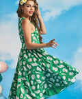 Side view of retro-inspired green seashell print dress with flowing skirt