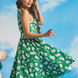 Side view of retro-inspired green seashell print dress with flowing skirt