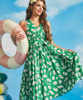 Model posing in green cotton seashell print resort wear dress with faux-wrap silhouette