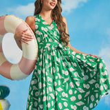 Model posing in green cotton seashell print resort wear dress with faux-wrap silhouette