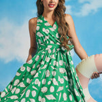 Front view of green sleeveless seashell print midi dress with wrap-style bodice
