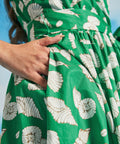 Detail of side seam pocket on green seashell print faux-wrap vacation dress