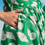 Detail of side seam pocket on green seashell print faux-wrap vacation dress