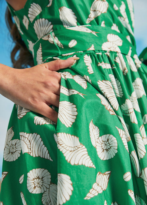 Detail of side seam pocket on green seashell print faux-wrap vacation dress