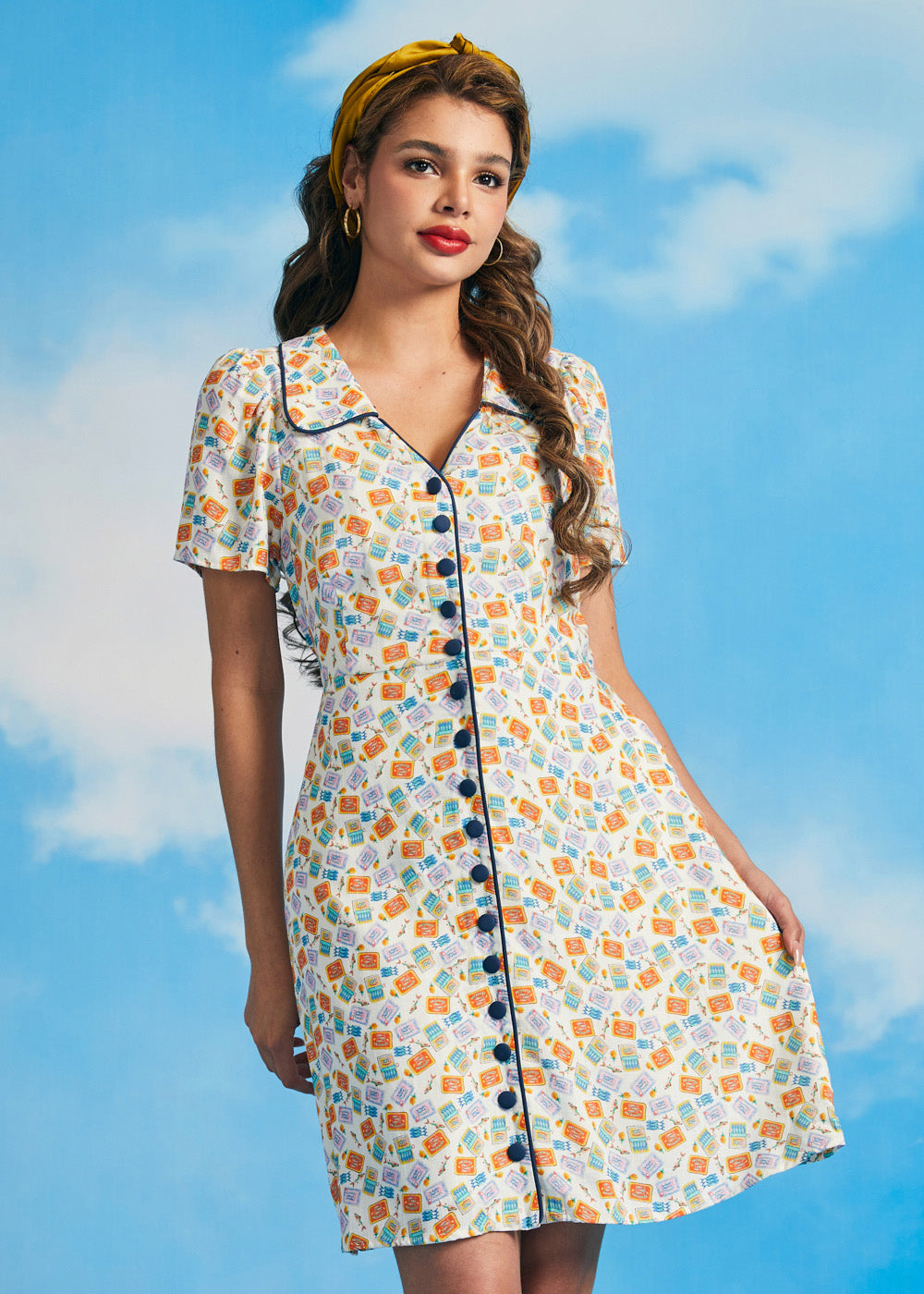 Woman wearing vintage-inspired sardine print dress with pockets and button front