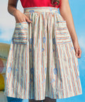 Woman wearing vintage-inspired seaside stripe dirndl skirt with oversized patch pockets and sleeveless red top