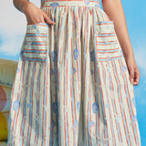Woman wearing vintage-inspired seaside stripe dirndl skirt with oversized patch pockets and sleeveless red top