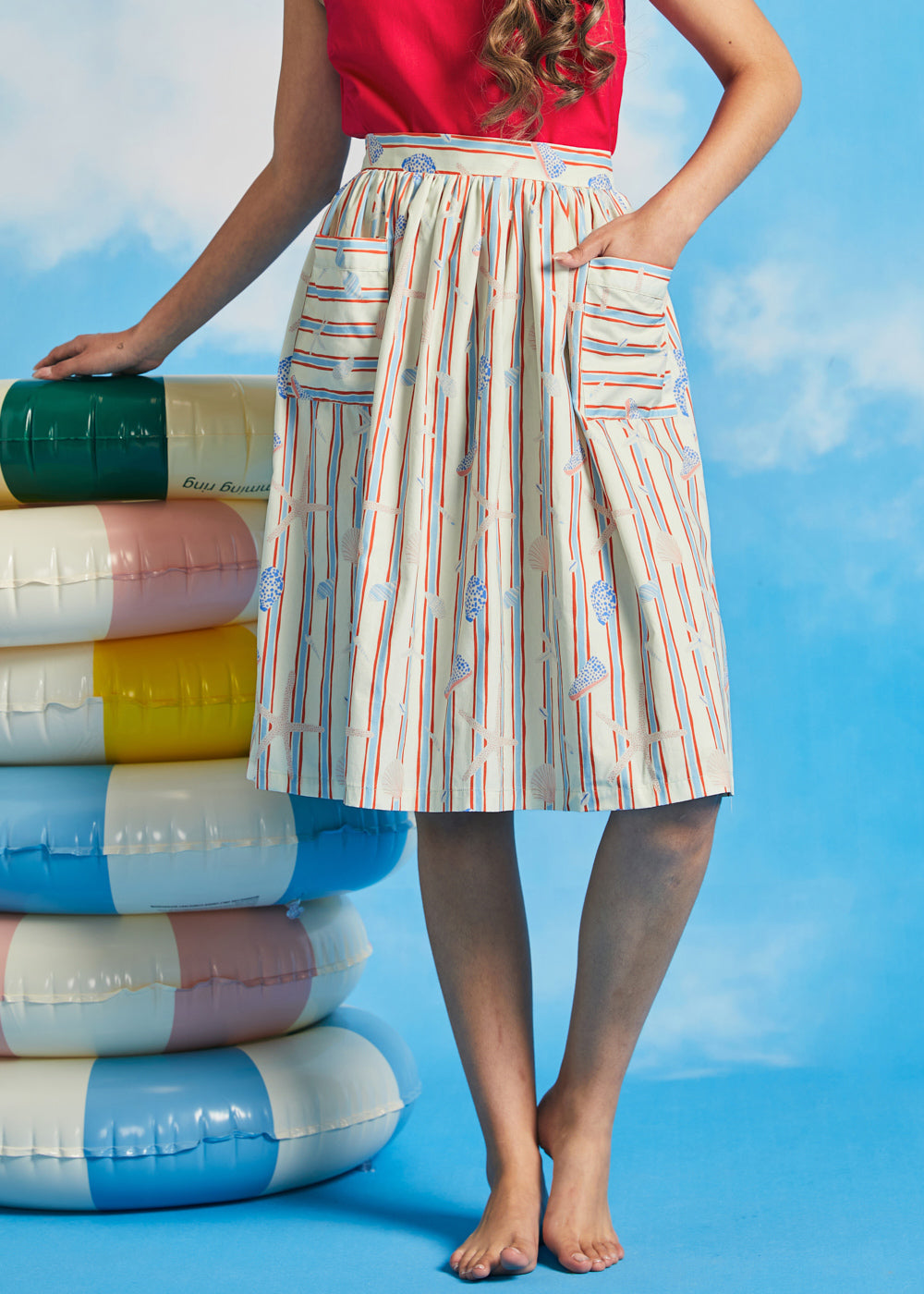 Woman modeling vintage-style gathered dirndl skirt with shell and starfish novelty print