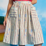 Close-up of cotton dirndl skirt with gathered waist and oversized patch pockets in starfish stripe print