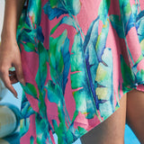 Close-up of tropical watercolor leaf print on pink textured fabric