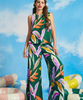 Woman wearing colorful tropical print sleeveless shell top with extra-wide palazzo pants