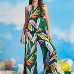 Woman wearing colorful tropical print sleeveless shell top with extra-wide palazzo pants