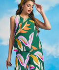 Woman styling colorful abstract print shell top with flowing palazzo pants