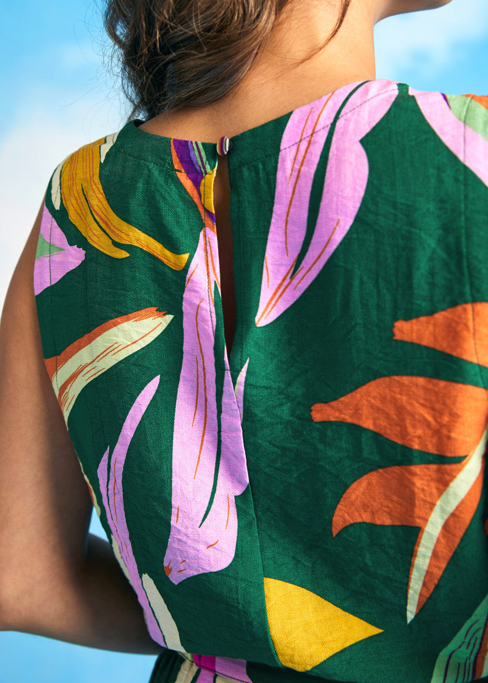 Close-up of round neckline and lightweight woven fabric on tropical print top