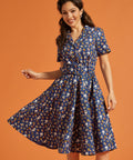 Woman wearing a blue quirky print dress with short sleeves