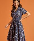 Woman wearing a blue dress with button front and multi color novelty print