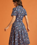 Back view of a woman wearing a blue vintage inspired fit and flare printed dress