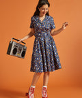 Woman in a blue cat and rainbow print dress with red roller skates and a retro boombox